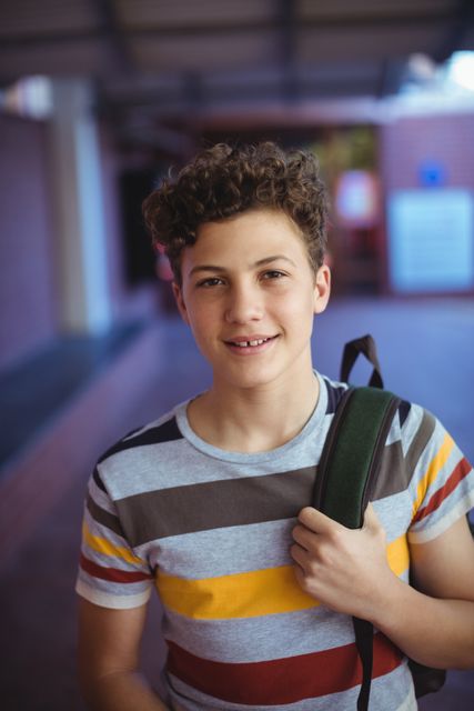 Portrait of happy schoolboy standing in school campus
