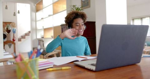 Boy engaged in online learning at home with headphones