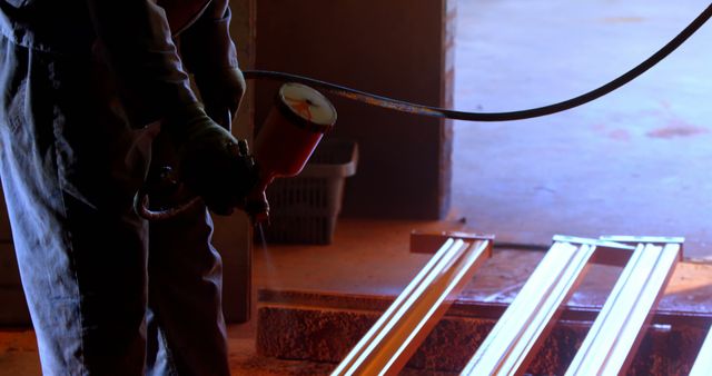 Worker Painting Metal Beams with Spray Gun in Dark Industrial Environment - Download Free Stock Images Pikwizard.com