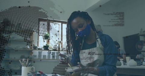 Artisan glazing ceramic bowl with digital overlay in pottery studio