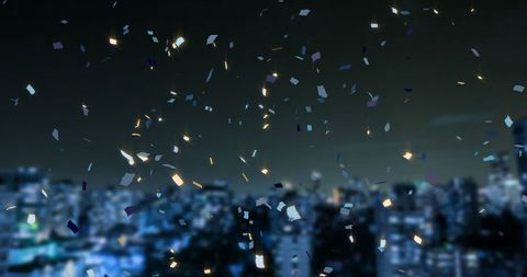 Confetti Falling Over Blurred Cityscape at Night