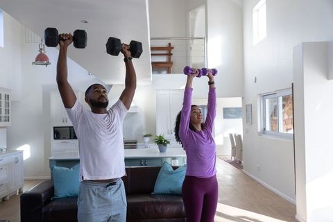 Fit Couple Engaging in Dumbbell Workout at Home