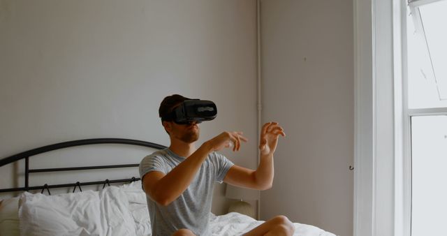 Young Man Using Virtual Reality Headset in Bedroom - Download Free Stock Images Pikwizard.com