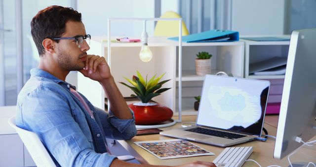 Young Professional Contemplating at Desk in Modern Office - Download Free Stock Images Pikwizard.com