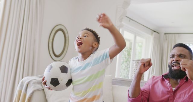 Excited Father and Son Celebrating Soccer Game Victory at Home - Download Free Stock Images Pikwizard.com