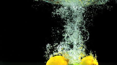 Lemons and Limes Splashing Underwater in Dramatic Slow Motion