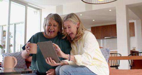 Diverse Female Friends Relaxing with Coffee and Technology in Modern Home