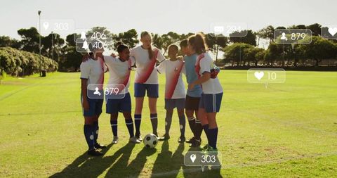 Women soccer team huddling on sunlit field with social media engagement icons