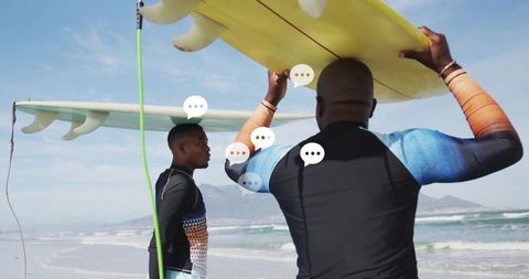 Father and Son Carrying Surfboards on Waves