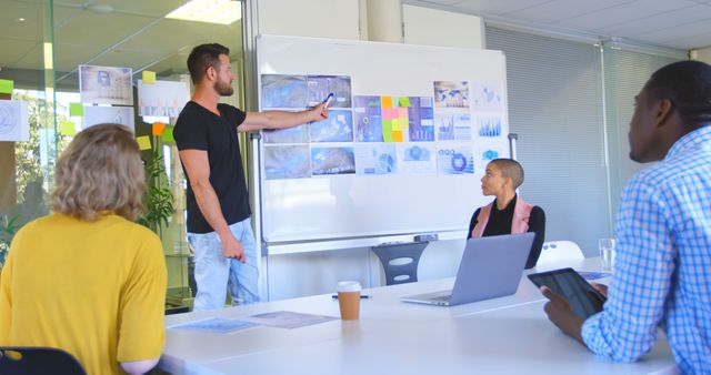 Diverse Team In Office Meeting With Presenter Pointing at Whiteboard - Download Free Stock Images Pikwizard.com