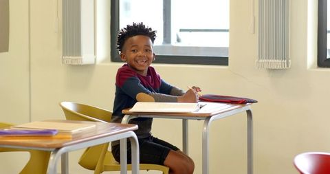 Joyful student writing during classroom activity