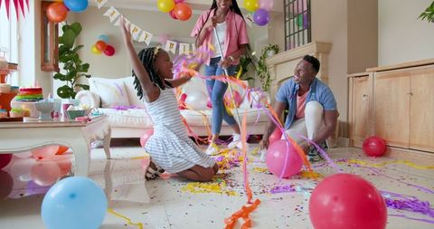 Happy Family Tidying After Child's Birthday Celebration at Home