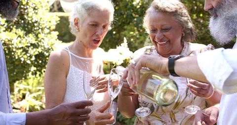 Senior Friends Celebrating an Outdoor Wedding with Champagne Toast