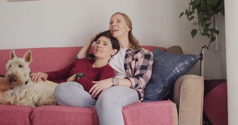 Happy Couple Relaxing on Sofa with Pet Terrier in Cozy Living Space