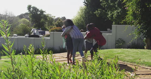 Family Embracing in Lush Garden on Sunny Day