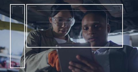 Coverall clad technicians analyzing vehicle issues in garage