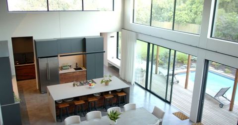 Modern open-plan kitchen showcasing central island and pool-facing glass doors