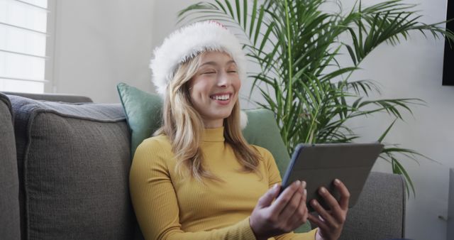 Young Woman Wearing Santa Hat Video Calling with Tablet - Download Free Stock Images Pikwizard.com