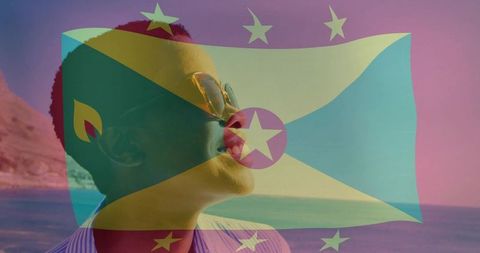 Woman gazing toward horizon with grenada flag overlay at tropical coastline sunset