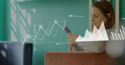 Woman checking mobile analytics with interactive data overlays in teal lounge for remote work