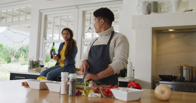 Image of happy biracial couple preparing meal together and drink wine - Download Free Stock Photos Pikwizard.com