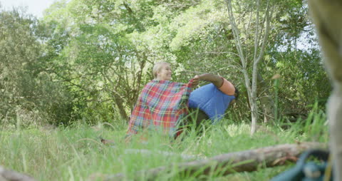 Diverse Couple Embracing Under Colorful Blanket in Park