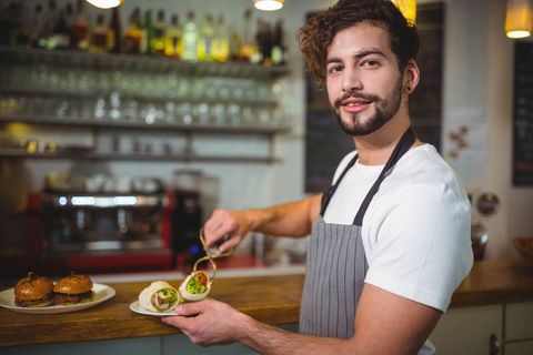 Smiling Barista Preparing Fresh Sandwiches in Cafe Scene