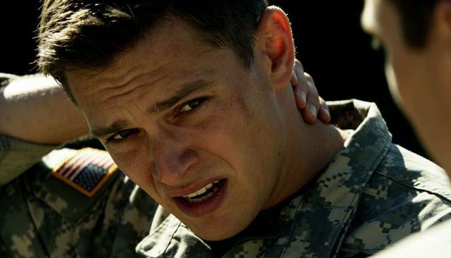 Us army soldier clutching neck squinting in harsh sunlight wearing camouflage uniform