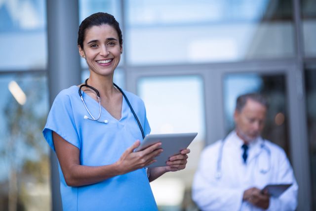 Smiling Nurse Using Digital Tablet in Hospital - Download Free Stock Images Pikwizard.com