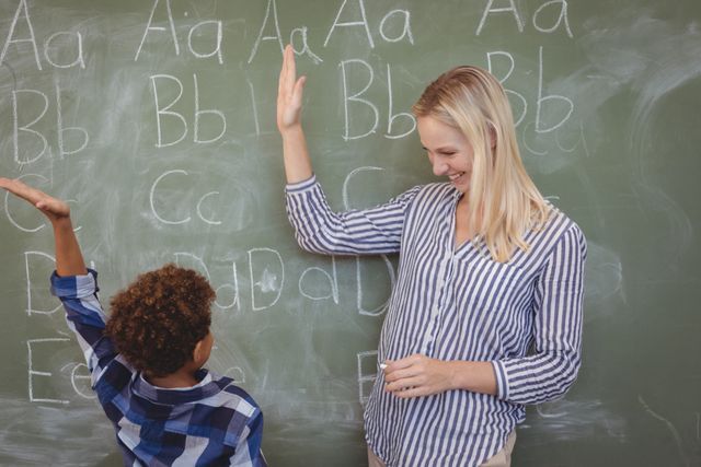 Teacher and Student High-Fiving in Classroom - Download Free Stock Images Pikwizard.com