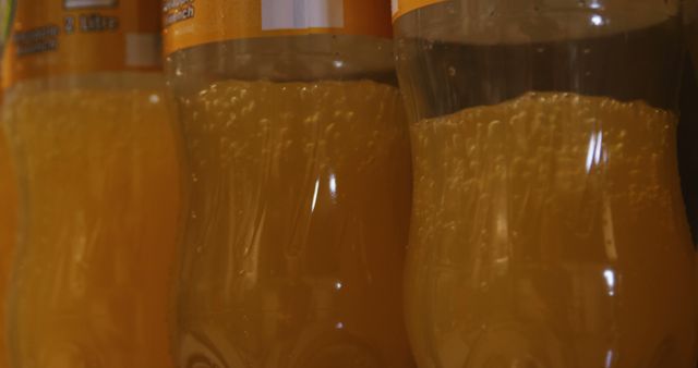 Close-up view of bottled orange juice with visible bubbles, highlighting the freshness and appeal of the drink. Ideal for promoting beverages, advertising health drinks, or featuring in food and drink-related content.