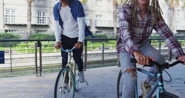 Two diverse male friends riding bicycles in street. green urban lifestyle, out and about in the city. .