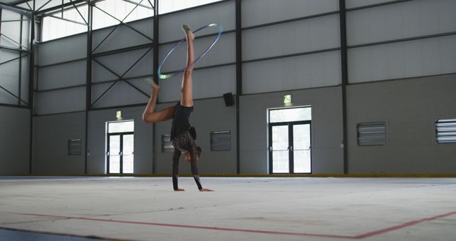 Female Athlete Performing Gymnastic Hoop Routine in Indoor Arena - Download Free Stock Images Pikwizard.com