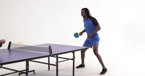 Young Man Playing Table Tennis Intently in Athletic Wear
