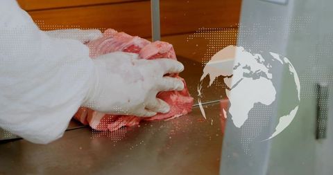 Butcher preparing meat on bandsaw with digital world map overlay