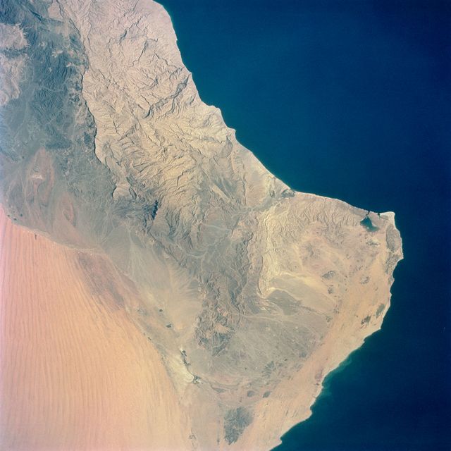 S65-34661 (3-7 June 1965) --- Among the photographs of Earth's terrain taken from the Gemini-4 spacecraft during its orbital mission was this view of the southeastern tip of the Arabian Peninsula with the Gulf of Oman at upper right. Seif dunes (sand) at lower left. This picture was taken with a modified 70mm Hasselblad camera, using Eastman color film, ASA 64 at a setting of 250th of a second at f/11. Dr. Paul Lowman Jr., NASA geologist, was in charge of the Synoptic Terrain Photography.