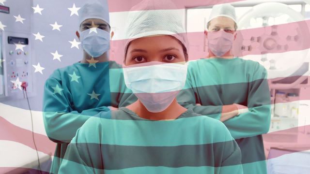 Medical professionals wearing surgical masks and green scrubs standing confidently in an operating room. The American flag overlays the scene, symbolizing national pride and dedication during the COVID-19 pandemic. Suitable for use in healthcare and medical services promotions, articles on pandemic response, or campaigns honoring healthcare heroes.