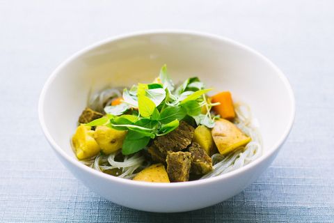 Hearty Asian-Style Beef Curry with Glass Noodles and Fresh Basil Garnish in White Bowl