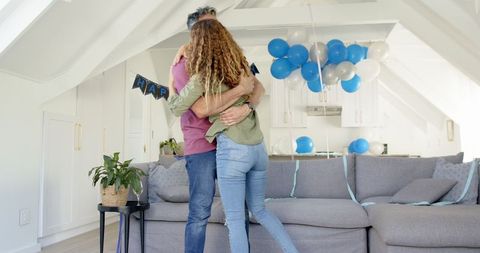 Happy Couple Dancing Together in Balloon Festooned Living Room