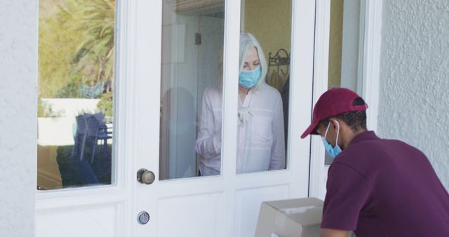 Deliveryman Wearing Mask Handing Package to Senior Woman - Download Free Stock Images Pikwizard.com