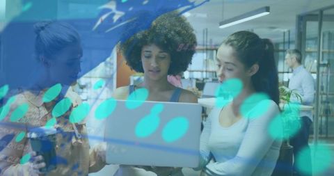 Diverse team collaborating over laptop with digital overlay in modern coworking space