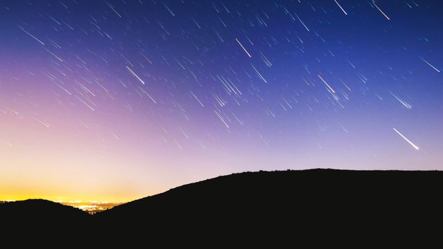 Beautiful view of star shower in night sky over the mountains. Nature and ecology concept