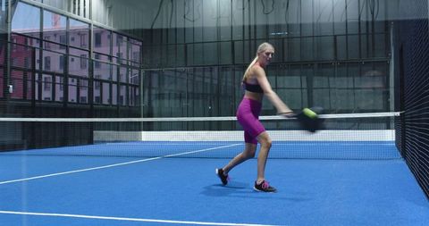 Athletic Woman Playing Padel on Indoor Sports Court