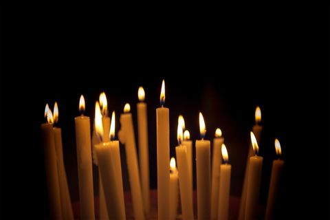 Group of Burning Candles Against Dark Background