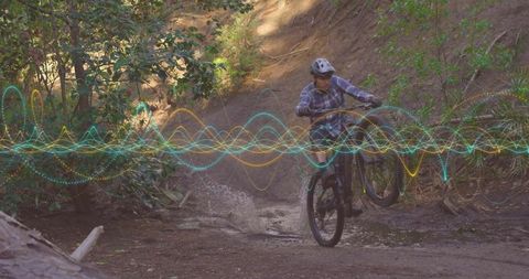 Mountain biker splashes through forest creek with digital effects