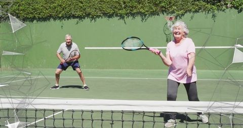 Seniors Enjoying Active Tennis Gameplay Outdoor on Sunny Day