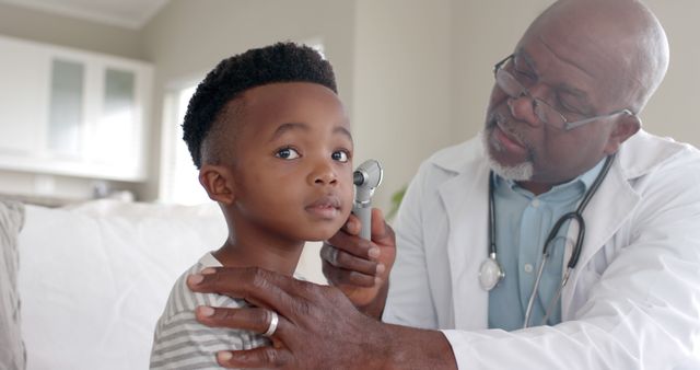Healthcare professional examining young boy with stethoscope at doctor's office. Great for content related to children's health, medical profession, pediatric services, healthcare providers, and family wellness.