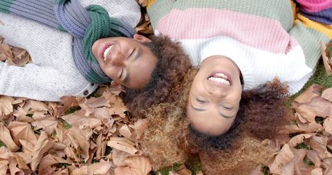 Joyful Mother and Son Relaxing on Autumn Leaves