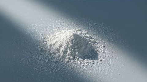 Mounded milk powder on smooth surface with scattered granules