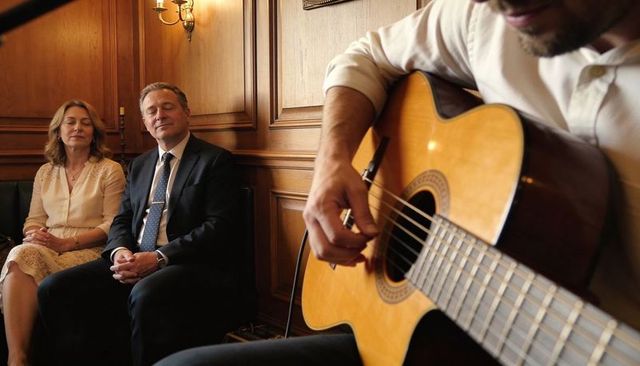 Intimate acoustic guitar performance in wood-panelled parlor with couple listening